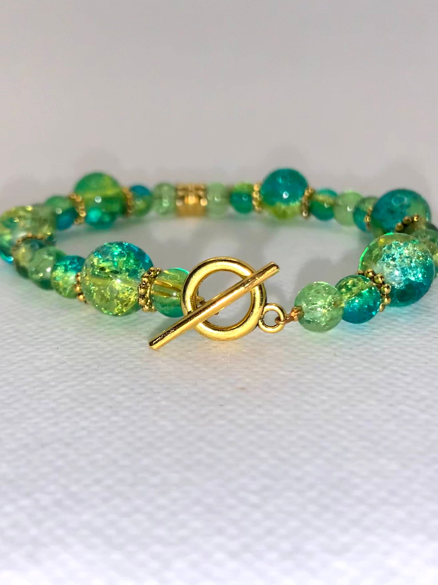 Green/Blue Crackle multi-size beaded bracelet with gold flower and clasp